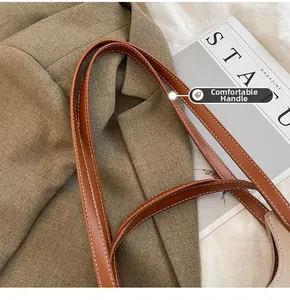 Détail de la bandoulière en cuir PU marron avec des coutures blanches contrastées