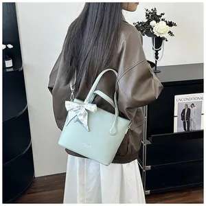 Nahaufnahme der mintgrünen Leder-Tote-Bag mit Litschimuster und dekorativem Seidenschal