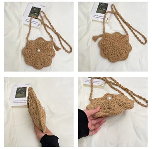 Detail view of khaki crochet flower crossbody bag with center pearl and tassel accessory