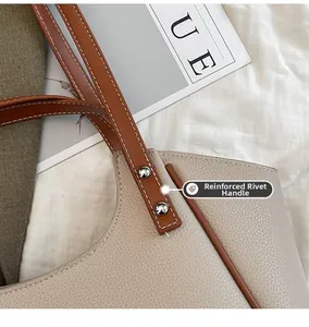 Détail de la poignée renforcée avec rivets argentés sur le sac cabas beige