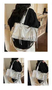 Detail of glossy grey motorcycle tote bag featuring leather tassels and metallic eyelets
