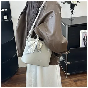 Detailaufnahme der hellgrauen Beuteltasche mit Lederstruktur und Seidenschal-Dekoration