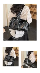 Detail of glossy black PU tote bag showing silver metal rings and punk fringe straps