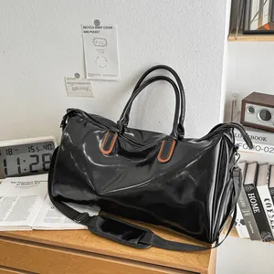 Waterproof black PU leather travel bag with brown handles and a detachable shoulder strap