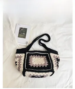 Detail of hand-crocheted tote bag featuring classic black and purple granny square patterns