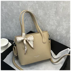 Detail der beigen Lederhandtasche mit Herz-Seidenschal in einer schwarzen Geschenkbox