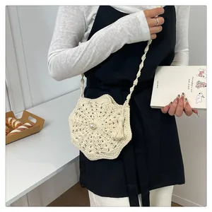 Detailed shot of cream crochet star bag with pearl center and elegant tassel accent