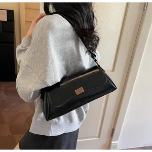 Dettaglio borsa a tracolla vintage in pelle verniciata nera con fibbia dorata chic