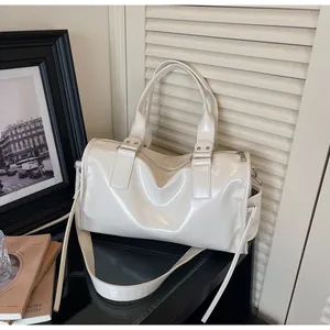 Detailed macro view of the glossy cream tote bag featuring silver hardware and wide strap