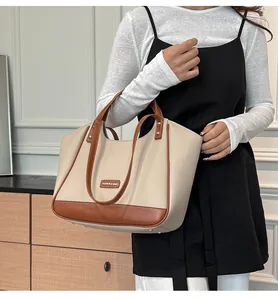 Détail du grand sac cabas avec texture litchi crème et finitions en cuir marron