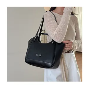 Gros plan du sac cabas noir en cuir grainé avec surpiq coutures blanches et logo