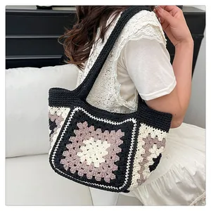 Detail of a handmade granny square crochet tote bag with woven shoulder strap