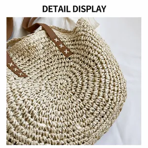 Primer plano de bolso de paja con detalles en cuero marrón y costuras decorativas