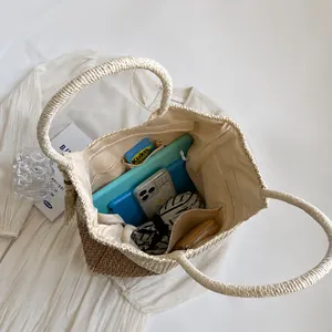 Interior view of dual-color woven straw bag showing large capacity for essentials