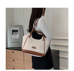 Détail du sac cabas minimaliste en cuir crème et marron avec texture litchi