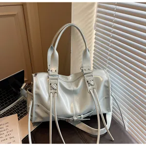 Detail of light blue glossy Boston bag with crossbody strap and lace-up tassel design