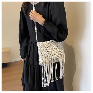 Detaillierte Makroansicht des Bohème Makramee-Musters und der langen Fransen an weißer Tasche
