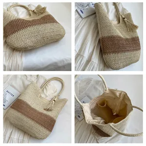 Detail of woven straw tote bag featuring contrast colors, tassel charm and spacious interior