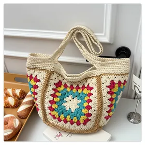 Detail of colorful geometric granny square crochet patterns on a beige knit tote bag