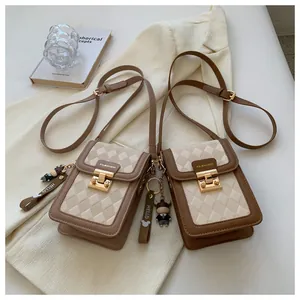 Close-up of quilted phone bags in brown and beige with golden fashion metal snaps