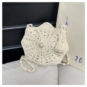 Chic cream straw beach bag with crochet floral pattern and central pearl accent