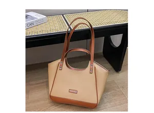 Détail du sac cabas en similicuir beige avec anses marron et rivets argentés