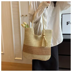 Detail view of woven tote bag with tricolor stripes and bohemian tassel ornament