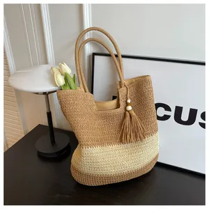 Detail of woven two-tone paper rope tote bag with tassel pendant and wooden beads