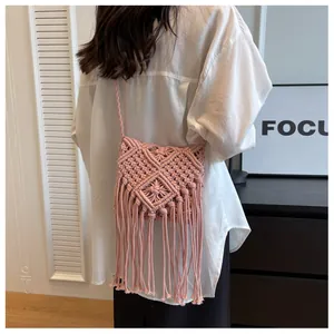 Detail der handgewebten Makramee-Tasche in Rosa mit Fransen an einem Model gezeigt