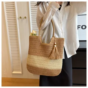 Detail of hand-woven straw tote with bicolor stripes and wooden bead tassel ornament