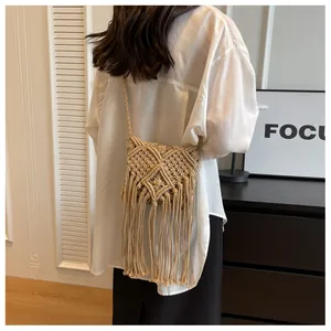 Detailansicht einer cremefarbenen gewebten Baumwolltasche im Boho-Stil mit Fransen und Schultergurt