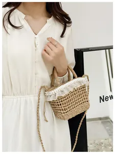 Detailed view of straw bucket bag featuring white lace trim and imitation pearl accents