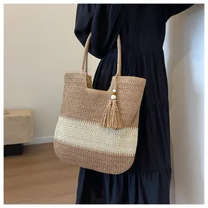 Detailed herringbone weave on a tri-color straw tote bag with elegant tassel and wood beads