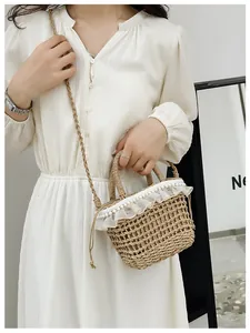 Detail of straw woven bucket bag featuring elegant white lace edges and pearl accents