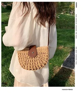 Detail of hollow-out straw weaving texture and leather saddle flap on crossbody bag