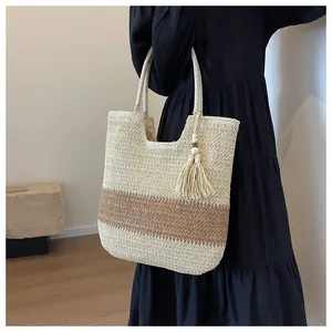 Close-up of woven paper straw tote bag with three-tone color block and tassel pendant