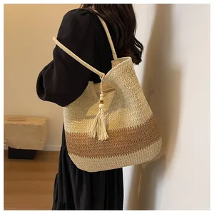 Close-up of woven straw tote bag with three-color gradient texture and tassel detail
