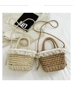 Detail view of straw bucket bag featuring pearl embellishments and lace trim ruffles
