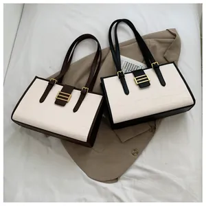 Detail of retro tote bags with embossed crocodile texture and gold metal hardware