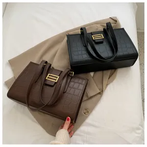 Detail shot of black and brown stone pattern leather tote bags with gold metal clasps