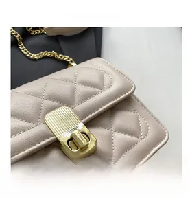 Gros plan de la texture cuir beige matelassé et du fermoir doré sur le sac à chaîne