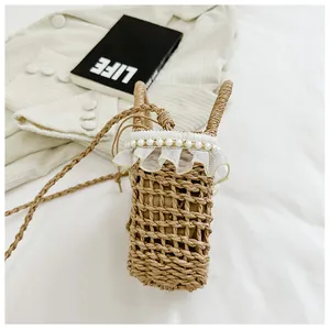 Detail of straw woven bucket bag with delicate white lace trim and pearl embellishments