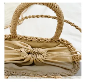 Detailed macro view of woven straw bucket bag with linen drawstring and braided handles
