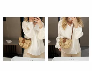 Detail of straw woven semi-circle bag with leather flap showing shoulder and crossbody wear