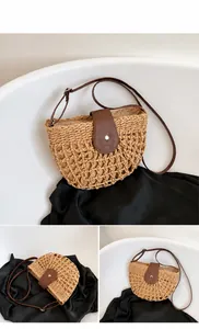 Detailed macro view of khaki hollowed-out woven straw bag with adjustable leather strap