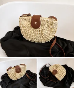 Detail of beige straw crossbody bag with mesh weave and brown leather strap