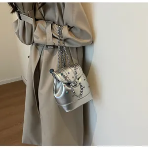 Silver Y2K mini backpack with colorful rhinestones and metal chain on a model