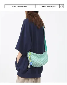 Detailweergave van de muntgroene halve maan crossbodytas met ruittextuur op een model