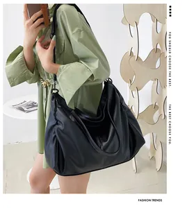 Detalle de un bolso de hombro grande en cuero PU negro suave con diseño de pliegues