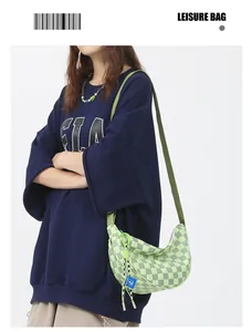 Detail van groene geruite crossbodytas met verstelbare riem en zijdelingse accenten